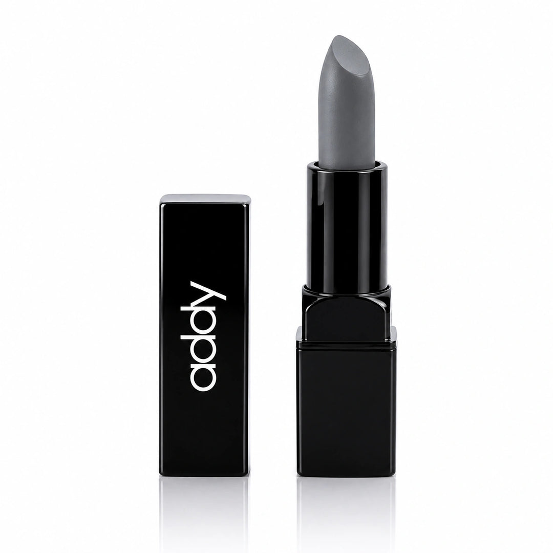 A matte gray lipstick in a glossy black rectangular tube, shown next to its matching black cap on a clean white background.