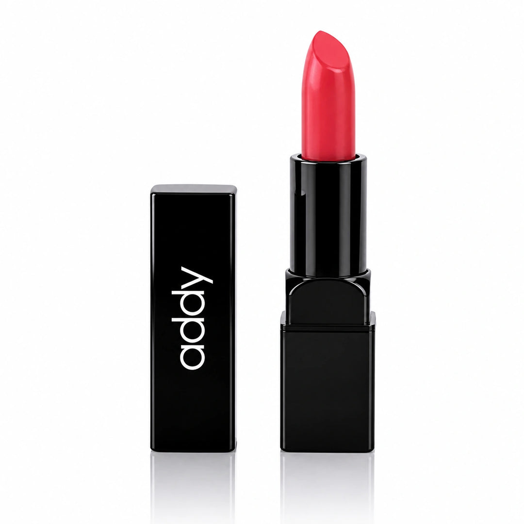 A red lipstick bullet standing upright in a black tube next to its matching black cap, which features the brand name 'addly' in white lowercase letters, set against a clean white background with a subtle reflection.